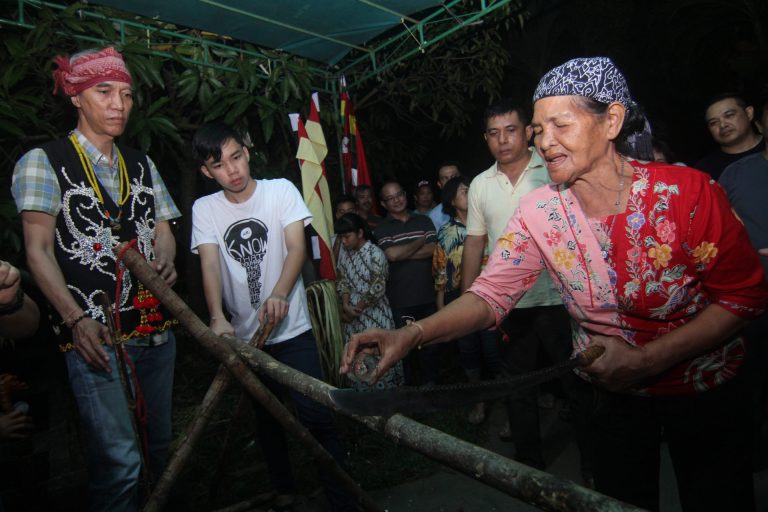 Seorang perempuan Suku Dayak Taman menuangkan minuman ke Mandau yang akan digunakan untuk menebas palang pintu saat menjalankan ritual Mararatatak atau buang pantang di kediaman keluarga ID Soeryamassoeka di Pontianak, Kalimantan Barat, Selasa (14/1/2020). Upacara buang pantang menurut adat Dayak Taman Kapuas Hulu tersebut untuk mengakhiri masa pantang berupa tidak bersenang-senang dan memutar musik yang telah dilakukan sebelumnya selama seminggu lebih karena berduka atas meninggalnya anggota keluarga. ANTARA FOTO/Jessica Helena Wuysang/pd.